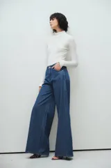 Pantalón palazzo de jean azul con rayas verticales blancas.