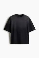 Remera negra de algodón con efecto desteñido, corte cuadrado, cuello redondo ribeteado, hombros caídos y mangas cortas con terminación desflecada.