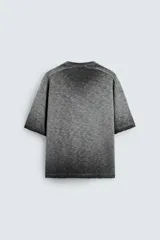 Camiseta gris de punto con efecto lavado, corte holgado, cuello redondo y mangas cortas.