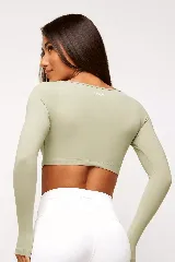 Top deportivo color verde oliva, de manga larga y escote cuadrado.