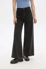 Pantalón de jean de tiro medio, color negro lavado, con corte ancho y pierna recta.