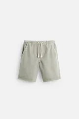 Bermuda relaxed fit confeccionada en denim de algodón color verde oliva. Cintura elástica ajustable con cordón. Bolsillos frontales y traseros de vivo.