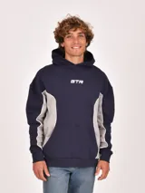 Buzo canguro negro con capucha, corte holgado y detalle de panel lateral en color verde oliva con ribete blanco. Presenta un estampado frontal con las letras "GTR".