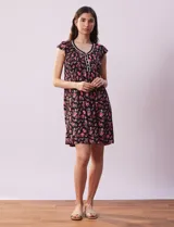 Camisón corto negro con estampado de lunares blancos, escote en V con puntilla blanca y botones.