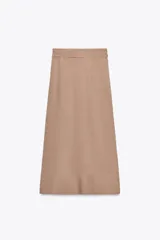 Falda midi color beige confeccionada en hilatura con viscosa. Tiene tiro alto, cintura con trabillas ajustable con lazada en el mismo tejido, detalle de doble pliegue en el delantero y bajo acabado con costuras marcadas a tono. Cierre lateral con cremallera oculta.