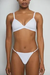 Conjunto de ropa interior de algodón blanco, compuesto por un corpiño triangulito de taza soft y una bombacha tipo tanga con laterales finos.