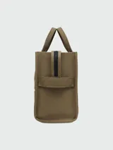 Bolso tote mediano color beige con estampado frontal del logo "The Tote Bag Marc Jacobs" en blanco. Tiene doble asa corta y correa larga extraíble de tela azul marino.