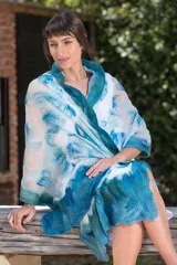 Echarpe blanca de gasa de seda natural con lana Merino superfina en tonos azules y turquesas, con volados en los extremos.