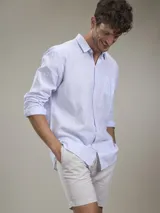 Camisa verde militar de manga larga, confeccionada en mezcla de lino y algodón. Tiene cuello clásico, cierre con botones y un bolsillo en el pecho.