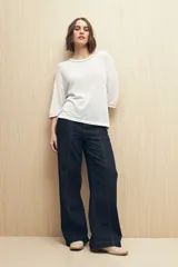 Pantalón de jean azul oscuro, de corte recto y tiro alto, con costuras a la vista.
