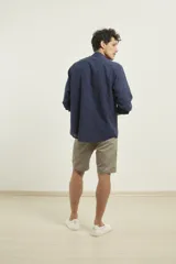 Bermuda de gabardina color azul oscuro, corte recto, con bolsillos laterales y traseros.