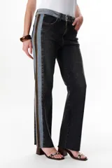 Pantalón de jean azul con paneles en distintos tonos de azul y marrón, corte recto y terminación desflecada.