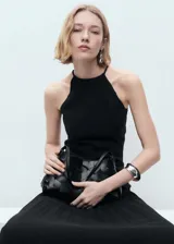 Vestido negro con cuello halter y falda plisada.