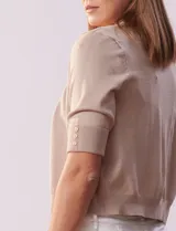 Bolero tejido color beige, marca Ninety, de manga corta con apliques de botones en los puños.