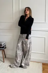 Pantalón baggy gris con estampado abstracto en tonos beige y blanco.