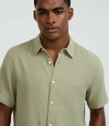 Camisa masculina de manga corta, cuello inglés y abotonado delantero, confeccionada en algodón con textura. Presenta un calce comfort más holgado.