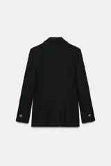 Blazer cruzado color beige, de manga larga, con cuello solapa y forro interior negro. Presenta cierre frontal con botones dorados y bolsillos de vivo en el pecho y bolsillos con solapa en el delantero.