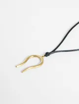 Collar con cordón negro ajustable y dije de acero dorado con forma de herradura.