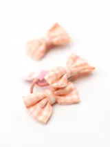 Set de dos coleros de pelo y un broche, con moñas de tela a cuadros color durazno y blanco.