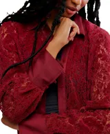 Camisa de manga larga color rojo oscuro, confeccionada en encaje floral con detalles en tela lisa (posiblemente satén) en el cuello, tapeta de botones y puños.