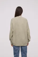 Cardigan de tejido holgado color crudo, con botones y mangas largas.