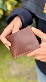 Billetera de cuero color marrón con el logo de la marca SierraMora grabado en la parte inferior.