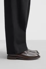 Zapato de vestir tipo derby, color marrón oscuro, con cordones, capellada de cuero brillante, forro y plantilla de cuero y suela plana.