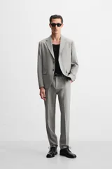 Pantalón de vestir gris claro con textura, corte regular fit, bolsillos laterales y traseros de doble vivo con botón. Cierre frontal con cremallera y botón.