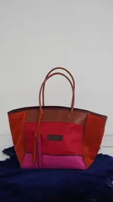 Bolso de fin de semana tipo tote bag, confeccionado en lona y gamuza, con detalles en cuero color marrón. Tiene un bolsillo interno con cierre.
