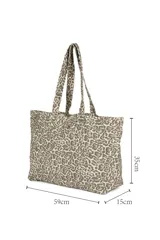 Bolso shopper con estampado animal print en tonos beige y marrón. Tiene doble asa de hombro y cierre superior.