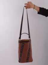 Bolso matero color bordó, de cuero, con doble asa (una de mano y otra larga desmontable), divisor interno para termo y mate, y bolsillo interior.