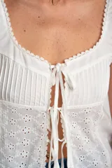 Musculosa blanca de algodón con bordado calado, alforzas y terminaciones de puntilla.