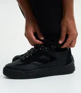 Pantalón baggy color beige, confeccionado en algodón con felpa. Presenta cintura elástica con cordón ajustable, bolsillos delanteros y un bolsillo trasero. El bajo es ajustable con elástico.