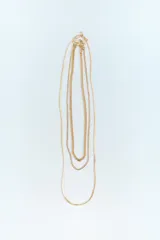 Set de tres collares dorados de diferentes largos. Incluye dos collares de cadena de eslabones metálicos y un collar de cadena tipo malla metálica.