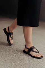 Sandalias marrones de cuero con tiras, microtachas doradas y hebilla lateral.