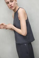 Camisa sin mangas color gris, confeccionada en 80% lino y 20% lino reciclado, con cuello redondo y corte recto.