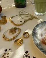 Anillo de diseño orgánico y macizo, realizado artesanalmente en bronce. Presenta una estructura abierta con dos piezas de forma irregular y textura rugosa.