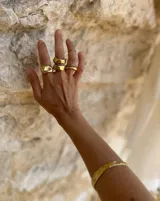 Brazalete rígido dorado con textura irregular.