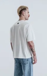 Remera blanca de algodón, corte crop y calce oversize, con hombros caídos y cuello redondo.