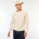 Sweater color crudo de punto fantasía con cuello redondo y mangas largas. Corte regular.