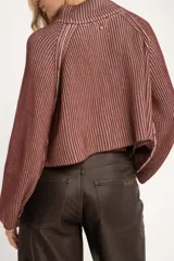 Sweater de punto morado con cierre metálico parcial en el cuello alto y mangas largas.