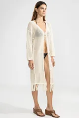 Cárdigan largo de punto abierto color crema con flecos en el ruedo y lazo de ajuste en el escote.