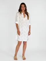 Vestido camisero blanco con bordado calado con motivos geométricos.