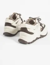 Zapatillas urbanas blancas con detalles en negro, cordones negros y suela chunky.