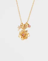 Collar corto dorado con cadena de eslabones y dijes colgantes: libélula, anillos y flor con centro de cristal rosado.