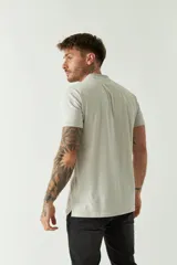 Remera polo negra de manga corta con cuello clásico, cierre de botones, bolsillo en el pecho y logo estampado.