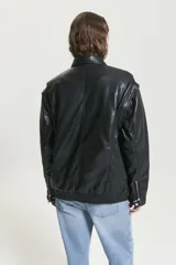 Campera negra de cuero sintético, con cuello clásico, cierre frontal con botones y bolsillos laterales. Diseño con detalles de costuras en los hombros y la espalda.