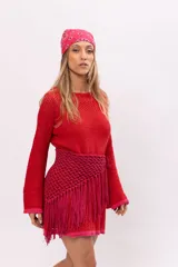 Vestido corto tejido a crochet color rojo con terminaciones en fucsia. Tiene mangas largas acampanadas y forro interior desmontable.