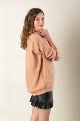 Poleron gris de tejido de punto, con cuello alto y corte holgado.