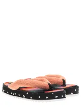 Sandalias con plataforma de goma blanca y base estampada con diseño abstracto en tonos negros, blancos y grises. Tira de tela blanca con textura.